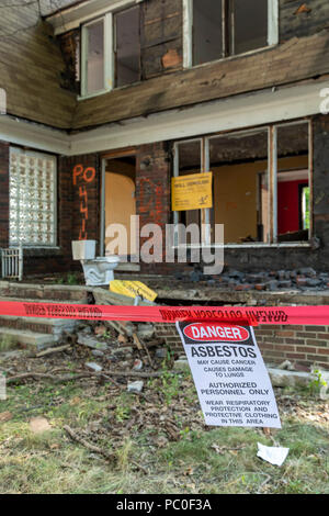 Detroit, Michigan - A warning about asbestos exposure hangs outside an abandoned house being prepared for demolition. The property will be used for a  Stock Photo