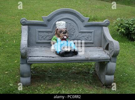 English bulldog as a cook sits on the Art Nouveau bench Stock Photo