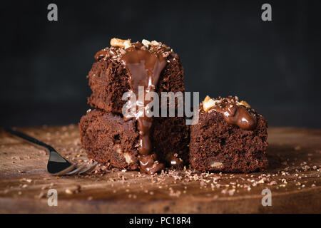 Chocolate brownies with chocolate glaze and walnuts on wood table. Closeup view Stock Photo