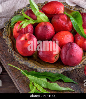 red ripe peaches nectarine in an iron plate, top view, close up Stock Photo