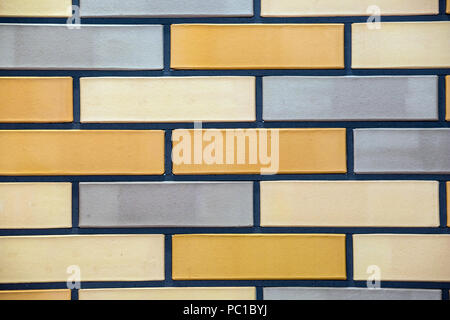 Tiles of house facade, blue, white and brown brick wall background. Stock Photo
