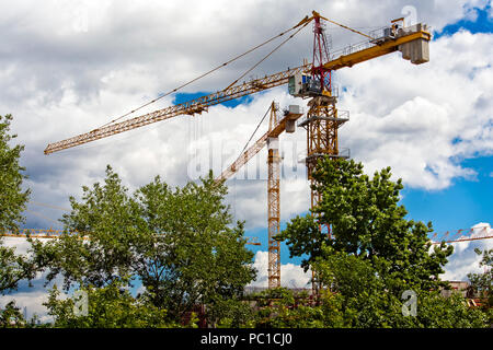 Two yellow building cranes on construction sites Stock Photo