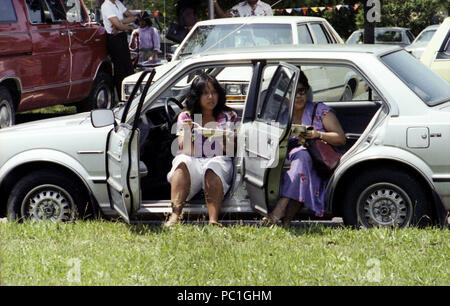 Two Filipino women eating in their car. Washington DC, 1988. Stock Photo