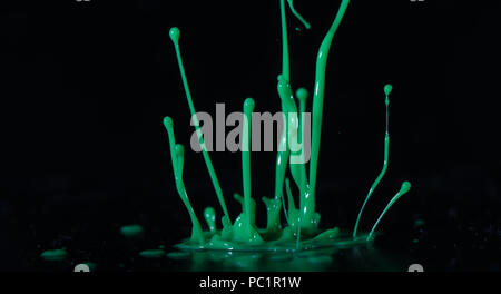 Green paint, ink splash on black background Stock Photo