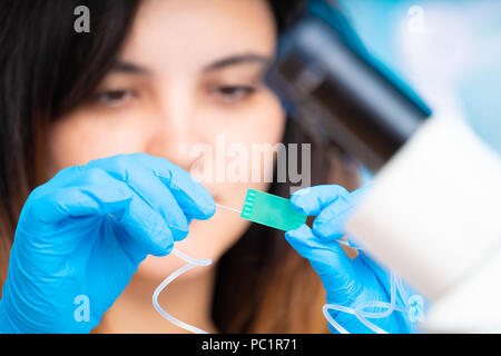 technician girl with microfluidic device LOC in microbiological lab Stock Photo