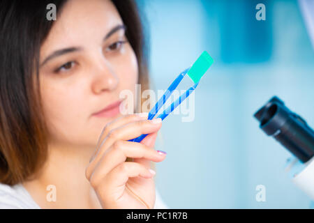 technician girl with microfluidic device LOC in microbiological lab Stock Photo
