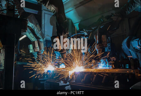 Industrial robots are welding merging automotive part in factory Stock Photo