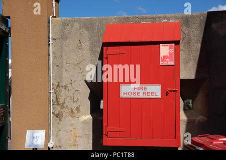 a wooden red box of Fire House Reel on a loft vintage cement wall Stock Photo