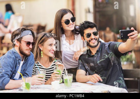 Multiracial group of best friends taking selfie at the cafe Stock Photo