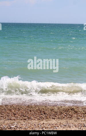 Tide coming in over a pebbled beach Stock Photo