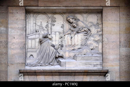 The Virgin giving the Rosary to Saint Dominic, by Theodore Charles Gruyere, relief on the portal of Saint Thomas Aquinas in Paris, France Stock Photo