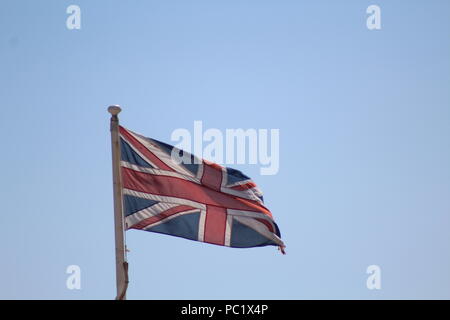 Union flag flying in blue skies Stock Photo