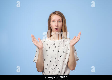 Surprised young woman smiling and holding her palms near face. She is shocked with sale prices. is it true. Stock Photo