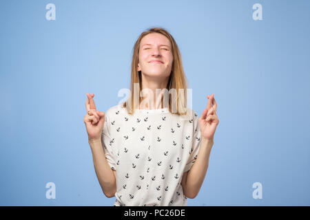 Lucky beautiful european female crosses fingers , hopes all wishes come true. Stock Photo