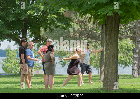 Group of young adults playing a game of bocce ball at Couchiching Beach Park in Orillia Ontario Canada. Stock Photo