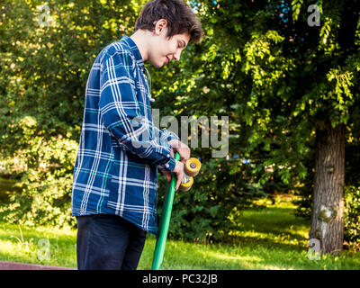 lifestyle young person walking with penny board in the city park Stock Photo