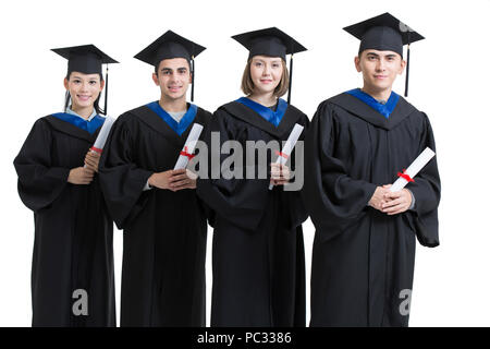 Happy college graduates in graduation gowns Stock Photo