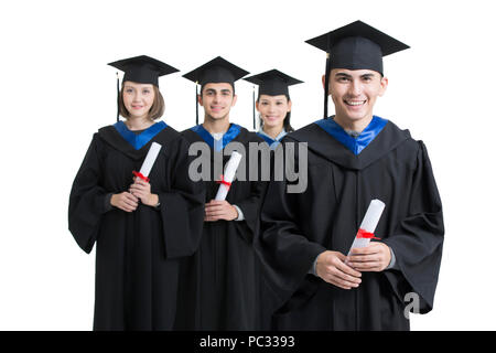 Happy college graduates in graduation gowns Stock Photo