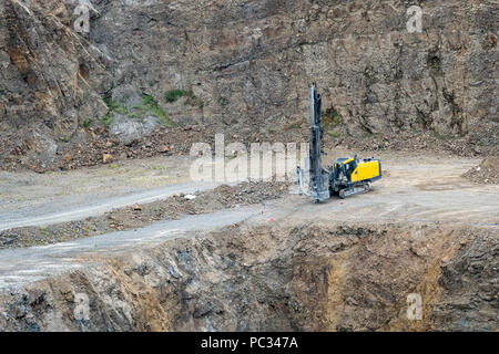 Opencast mining quarry with mining drilling machine. Mining in the granite quarry. Mining industry. Stock Photo