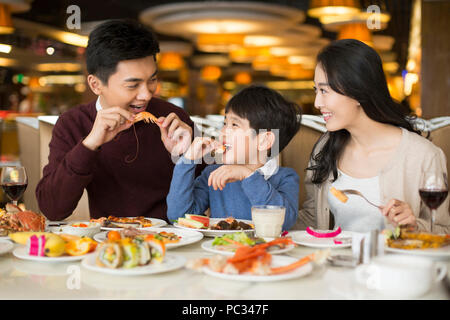 Cheerful young Chinese family having buffet dinner Stock Photo