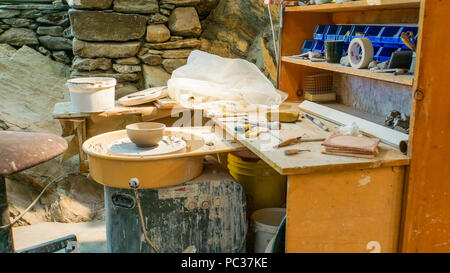 potter's studio or workshop with wheel, tools, clay, bowl in progress Stock Photo