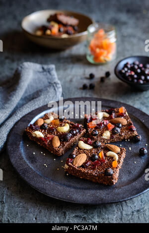 No bake chocolate puffed quinoa bars with freeze dried black currant, candied papaya, cashew nuts, almonds and cranberries Stock Photo