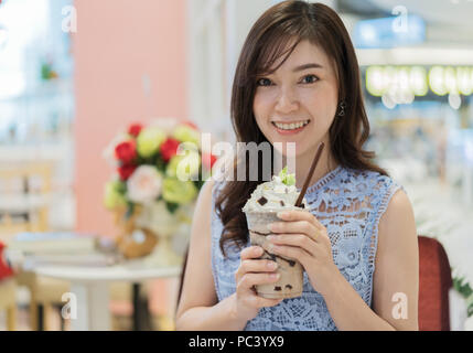 woman drinking a cup of chocolate milk at a cafe Stock Photo