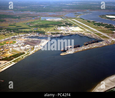 Aerial NS Mayport with CV-60 and CV-64 1993. An aerial view, looking southwest, showing the harbor at the naval station with two aircraft carriers, the USS CONSTELLATION (CV-64) and the USS SARATOGA (CV-60), moored at the carrier pier.  To the upper right in the photograph is the main runway at Naval Air Station Mayport. Stock Photo