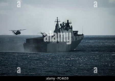 180729-M-QH615-0017 MARINE CORPS BASE HAWAII (July 29, 2018) Two CH-53E Super Stallion helicopters assigned to Marine Heavy Helicopter Squadron 463 (HMH-463) land aboard the Royal Australian Navy landing helicopter dock ship HMAS Adelaide (L01) during an amphibious landing demonstration as part of Rim of the Pacific (RIMPAC) exercise at Pyramid Rock Beach on Marine Corps Base Hawaii July 29, 2018. RIMPAC provides high-value training for task-organized, highly capable Marine Air-Ground Task Force and enhances the critical crisis response capability of U.S. Marines in the Pacific. Twenty-five na Stock Photo