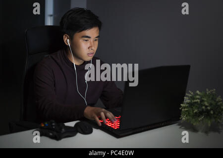 young man using laptop computer on table at night Stock Photo
