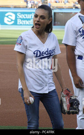 Mila Kunis sports fitted LA Dodgers jersey and skinny jeans to throw the  game's first pitch