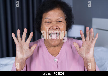 senior woman with surprised expression in bedroom Stock Photo