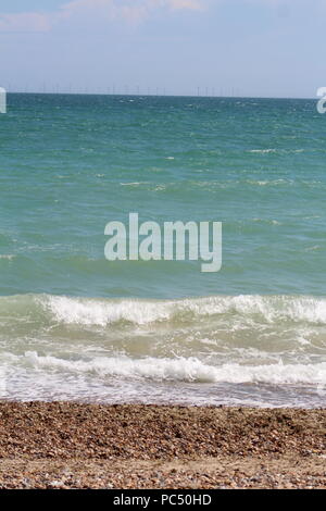 Tide coming in over a pebbled beach Stock Photo