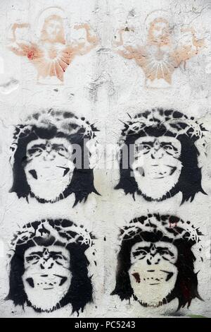 Stenciled image of Jesus Christ and monkeys wearing a crown of thorns, on a wall. Caricature.  Hanoi. Vietnam. | usage worldwide Stock Photo