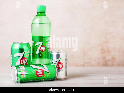 LONDON, UK - AUGUST 03, 2018: Plastic bottle and aluminium cans of 7UP citrus soda drink on wood. Stock Photo