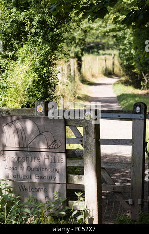 Offa's Dyke long distance footpath passes through a waymarked kissing gate and on into the Shropshire Hills Area of Outstanding Natural Beauty Stock Photo