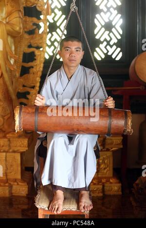 Linh An buddhist pagoda.  Young monk ringing bell in monastery.  Dalat. Vietnam. | usage worldwide Stock Photo