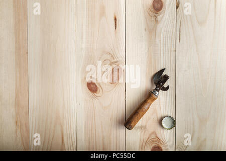 Vintage Opener near the lid of beer, on a wooden background, space for text Stock Photo