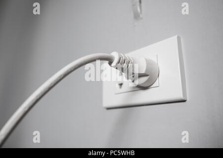 White electricity plug in the socket Stock Photo