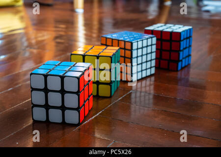 Bangkok, Thailand - April 25, 2018 : Various kind of Rubik's cubes on wooden floor. Stock Photo