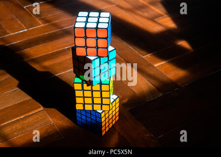 Bangkok, Thailand - April 25, 2018 : Various kind of Rubik's cubes on wooden floor. Stock Photo