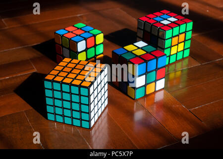Bangkok, Thailand - April 25, 2018 : Various kind of Rubik's cubes on wooden floor. Stock Photo