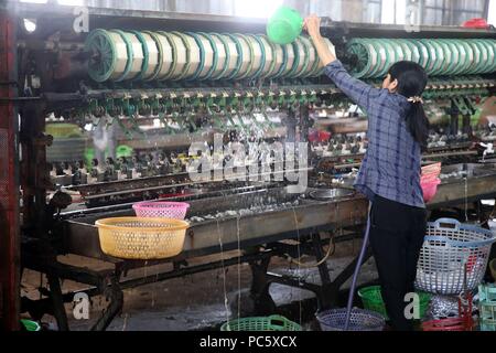 Traditional silk factory.  Woman working on silk spinning machine.  Dalat. Vietnam. | usage worldwide Stock Photo