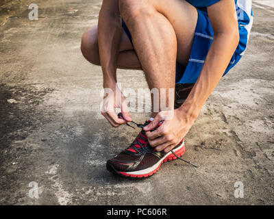 Male runner tying running shoes laces Stock Photo