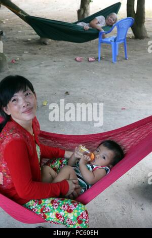 Mother and child relaxing in hammock. Thay Ninh. Vietnam. | usage worldwide Stock Photo