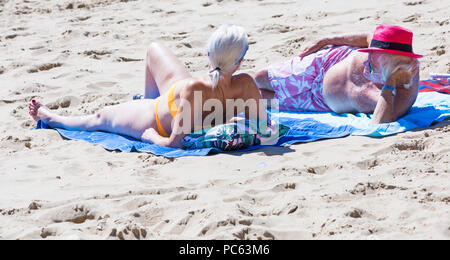 Bournemouth, Dorset, UK. 31st July 2018. UK weather:  the sun returns and temperatures rise as beach-goers head to the seaside to enjoy the warm sunny weather. Mature couple sunbathing on the beach. Credit: Carolyn Jenkins/Alamy Live News Stock Photo