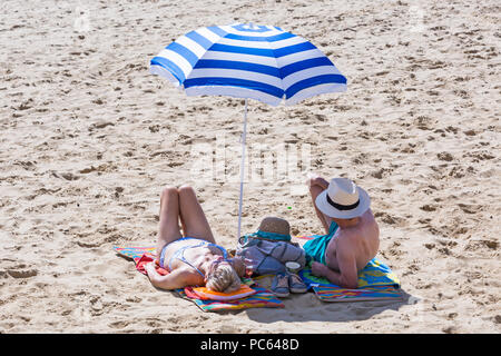 Bournemouth, Dorset, UK. 31st July 2018. UK weather:  the sun returns and temperatures rise as beach-goers head to the seaside to enjoy the warm sunny weather. Senior couple sunbathing on beach. Credit: Carolyn Jenkins/Alamy Live News Stock Photo