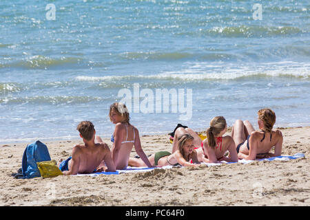 Bournemouth, Dorset, UK. 31st July 2018. UK weather:  the sun returns and temperatures rise as beach-goers head to the seaside to enjoy the warm sunny weather. Row of sunbathers at the seashore. Credit: Carolyn Jenkins/Alamy Live News Stock Photo