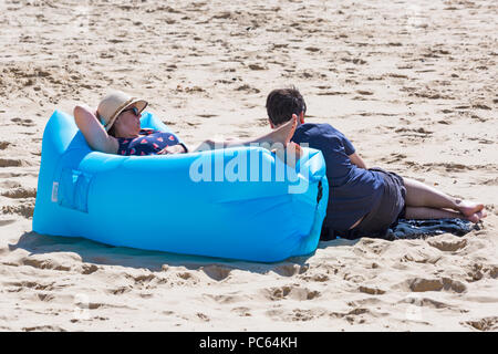 Bournemouth, Dorset, UK. 31st July 2018. UK weather:  the sun returns and temperatures rise as beach-goers head to the seaside to enjoy the warm sunny weather. Relaxing on inflatable lounger couch. Credit: Carolyn Jenkins/Alamy Live News Stock Photo