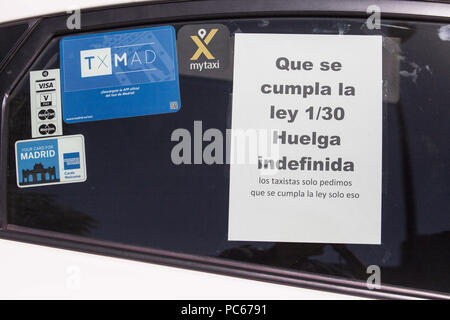 Madrid, Spain. 31st July, 2018. A poster at the window of a taxi that says, Let Law 1/30 be fulfilled. Indefinite strike.Taxi drivers in Madrid and throughout Spain decided to strike indefinite after meeting with the Ministry of Development. They strike against Uber and Cabify. Credit: Lito Lizana/SOPA Images/ZUMA Wire/Alamy Live News Stock Photo